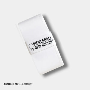 White pickleball grip doctor with black text on a light gray background