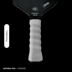 Pickleball paddle with black top and white handle on a black background