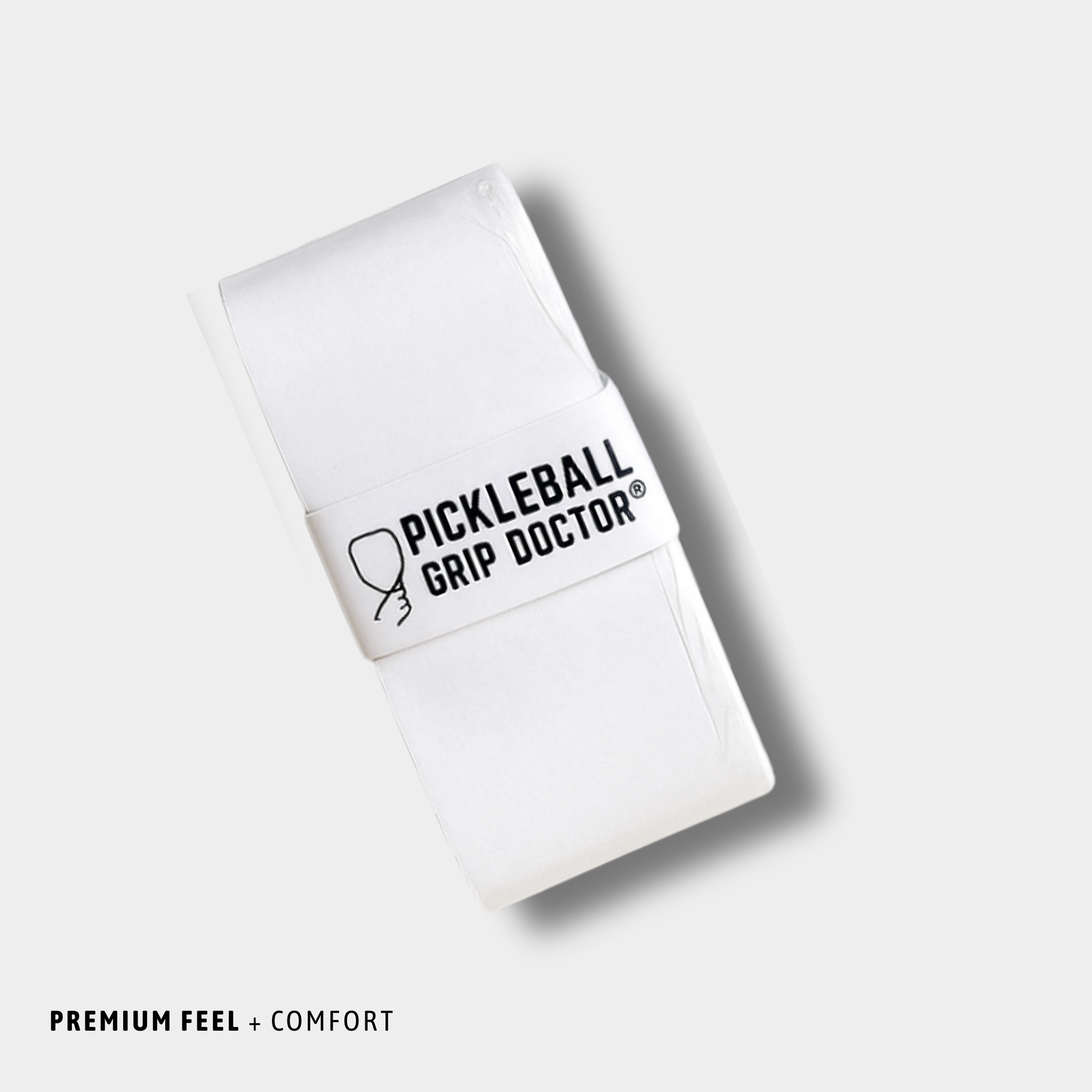 White pickleball grip doctor with black text on a light gray background